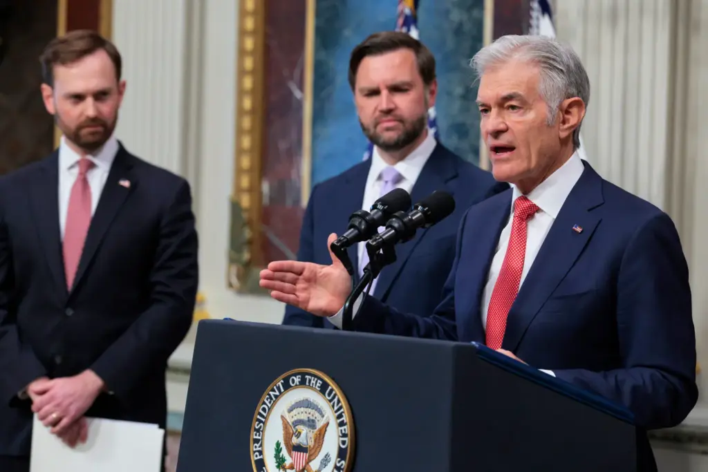Administrator for the Centers for Medicare & Medicaid Services Dr. Mehmet Oz (R) speaks alongside Chairman of the Federal Trade Commission (FTC) Andrew Ferguson (L) and U.S. Vice President JD Vance (C) during a press conference on the Trump administration's anti-fraud initiatives at the Eisenhower Executive Office Building on May 13, 2026, in Washington, D.C.
