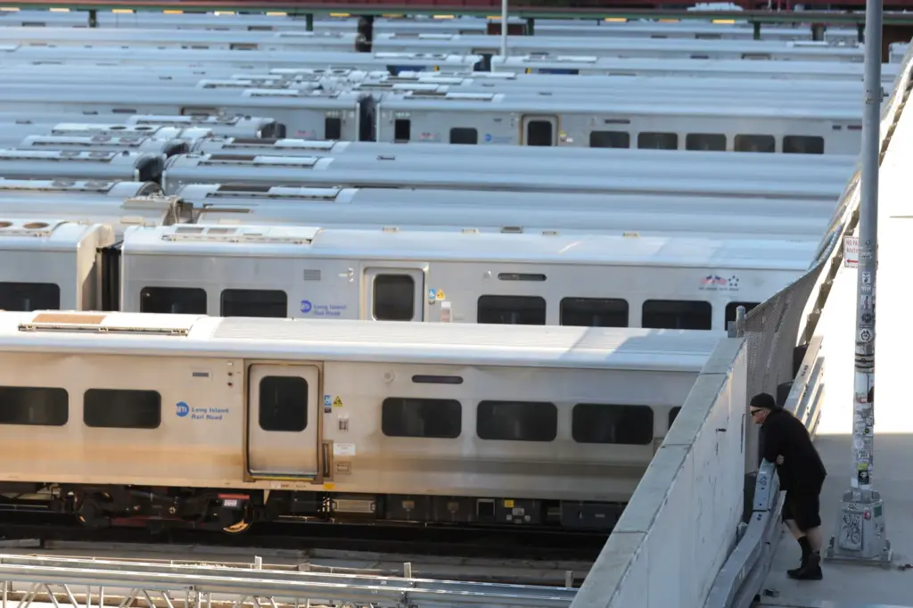 Pedestrians look out at the trains at the West Side Yard on the first day of a Long Island Rail Road strike, on May 16, 2026, in New York.