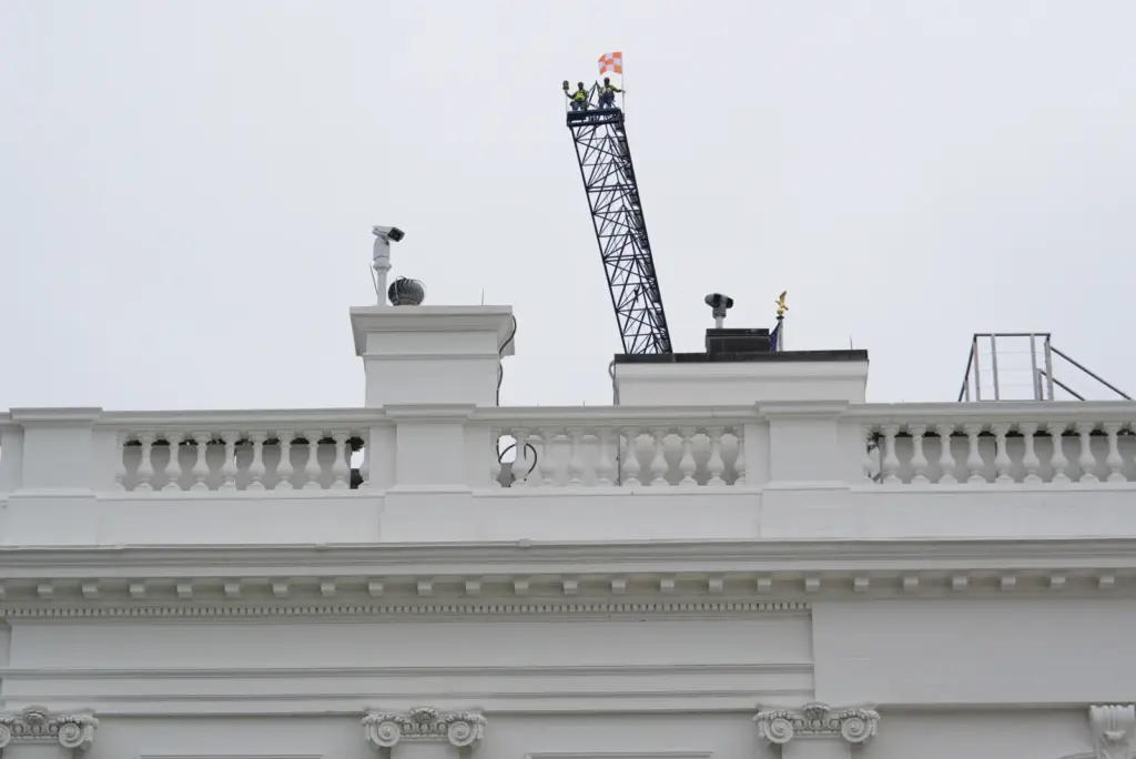 Two people look down at the White House from a crane on April 28 in Washington. (AP Photo/Julia Demaree Nikhinson)
