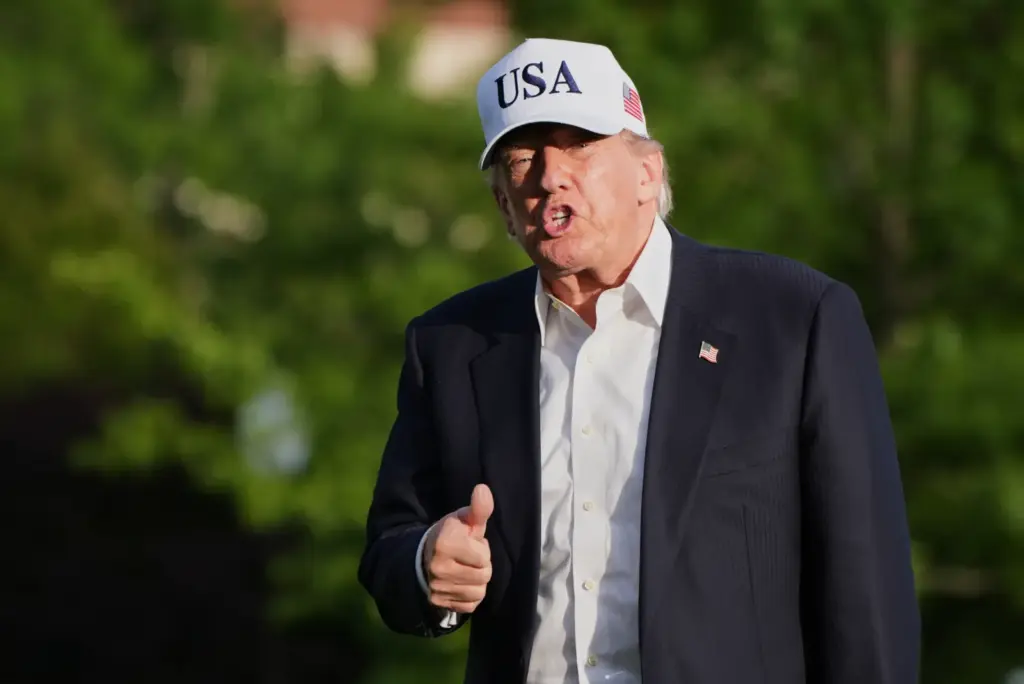 President Donald Trump gestures to reporters as he walks across the South Lawn of the White House, Friday, May 15, 2026, in Washington, on return from Beijing where he met with China's President Xi Jinping.