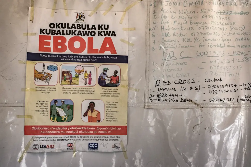 A poster displaying Ebola emergency contact numbers is pinned to a tent at the Busunga border crossing between Uganda and the DRC in Bundibugyo, on May 18, 2026.